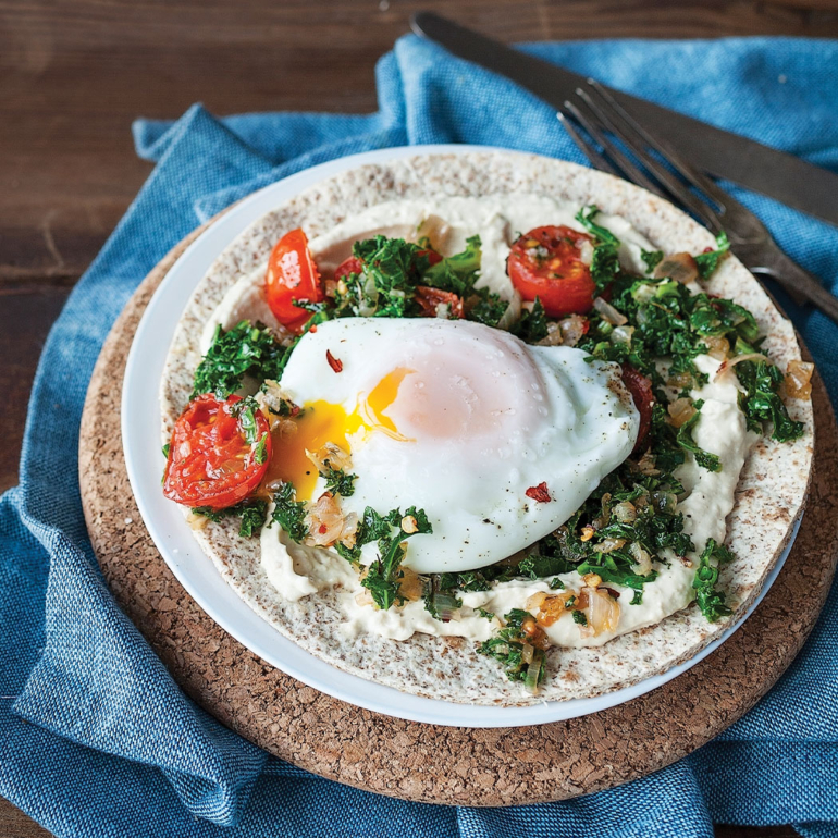 Kale and tomato breakfast wraps with runny eggs