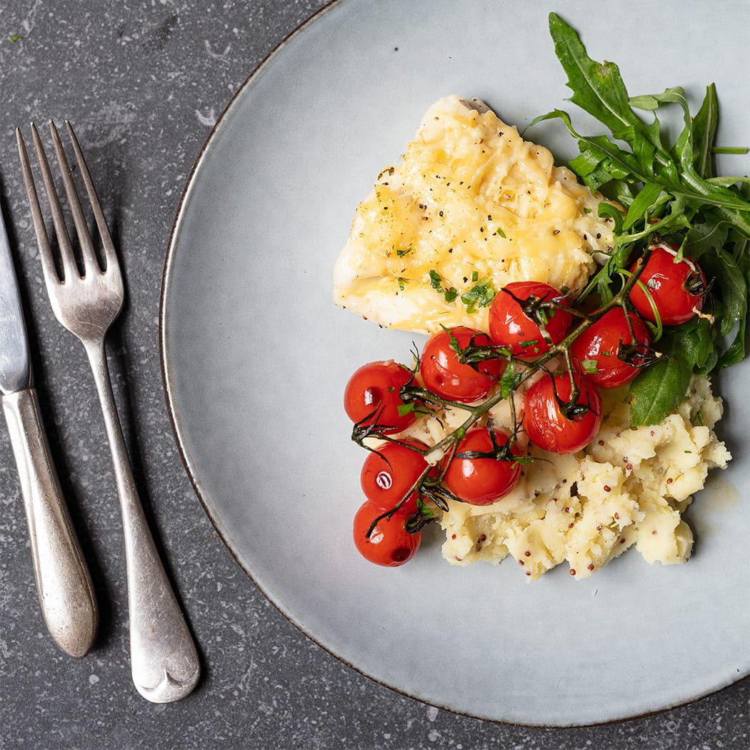 Cheesy cod with cherry tomatoes and mustard mash | easyFood