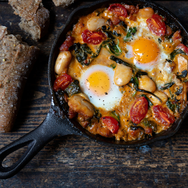 One-pan beans with eggs, spinach and bacon