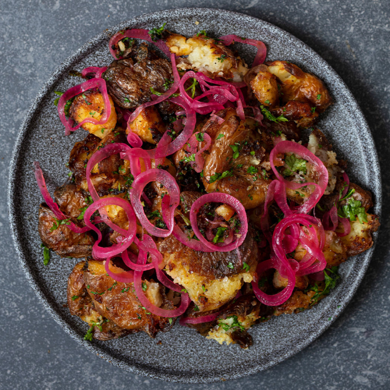 Smashed spiced baby roasties with pickled onions