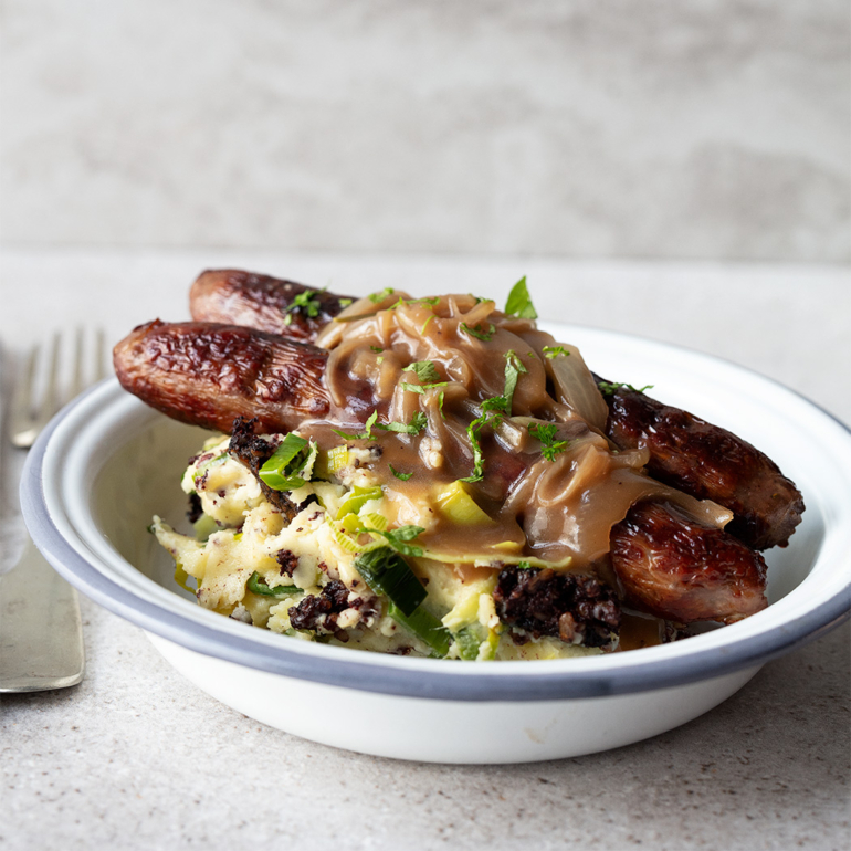 Venison bangers and black pudding leek mash with stout and onion gravy