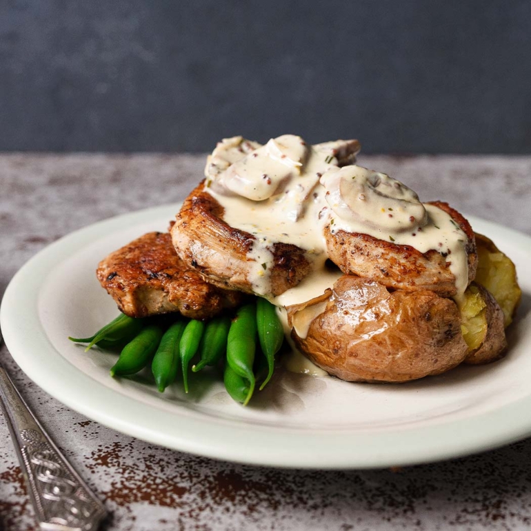 Pork medallions with baked potatoes and mushroom sauce